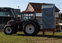 Traktor mit mobilen Silo Anhänger auf einem Stahlgestell